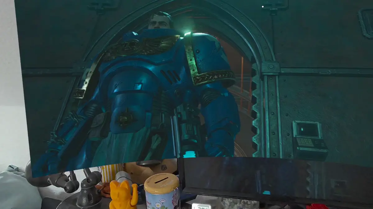 Blick unter die virtuelle Leinwand in Virtual Desktop: freche Katzenfigur auf dem Sideboard, darüber ragt Titus in Space Marine 2 auf