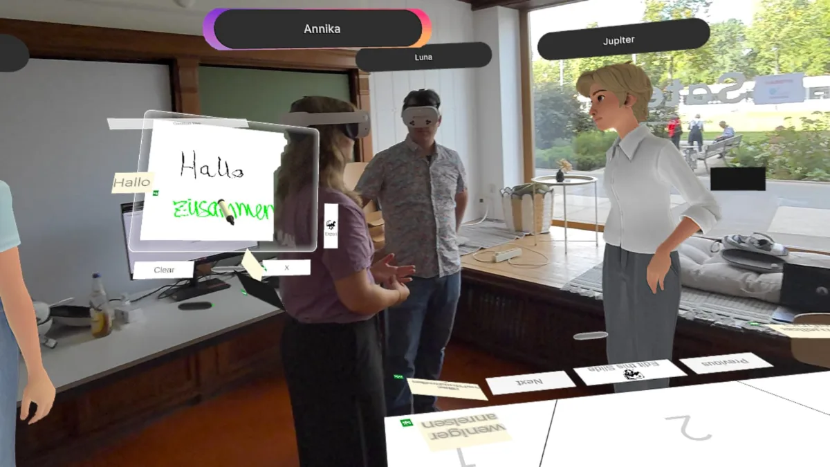 Mixed-Reality-Workshop mit HYBEAM: echte Teilnehmer im Passthrough, Whiteboard mit Hallo zusammen und der Avatar Jupiter aus Köln