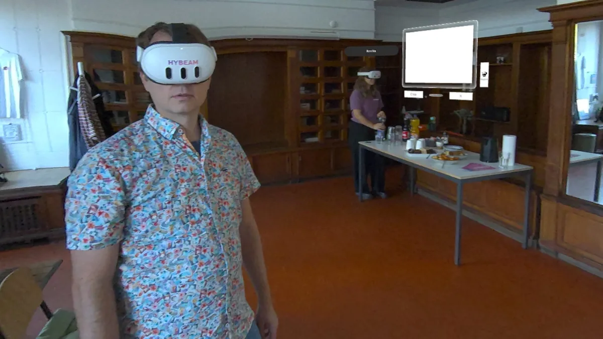 Teilnehmer mit HYBEAM Meta Quest 3 im Passthrough, dahinter ein virtuelles Whiteboard
